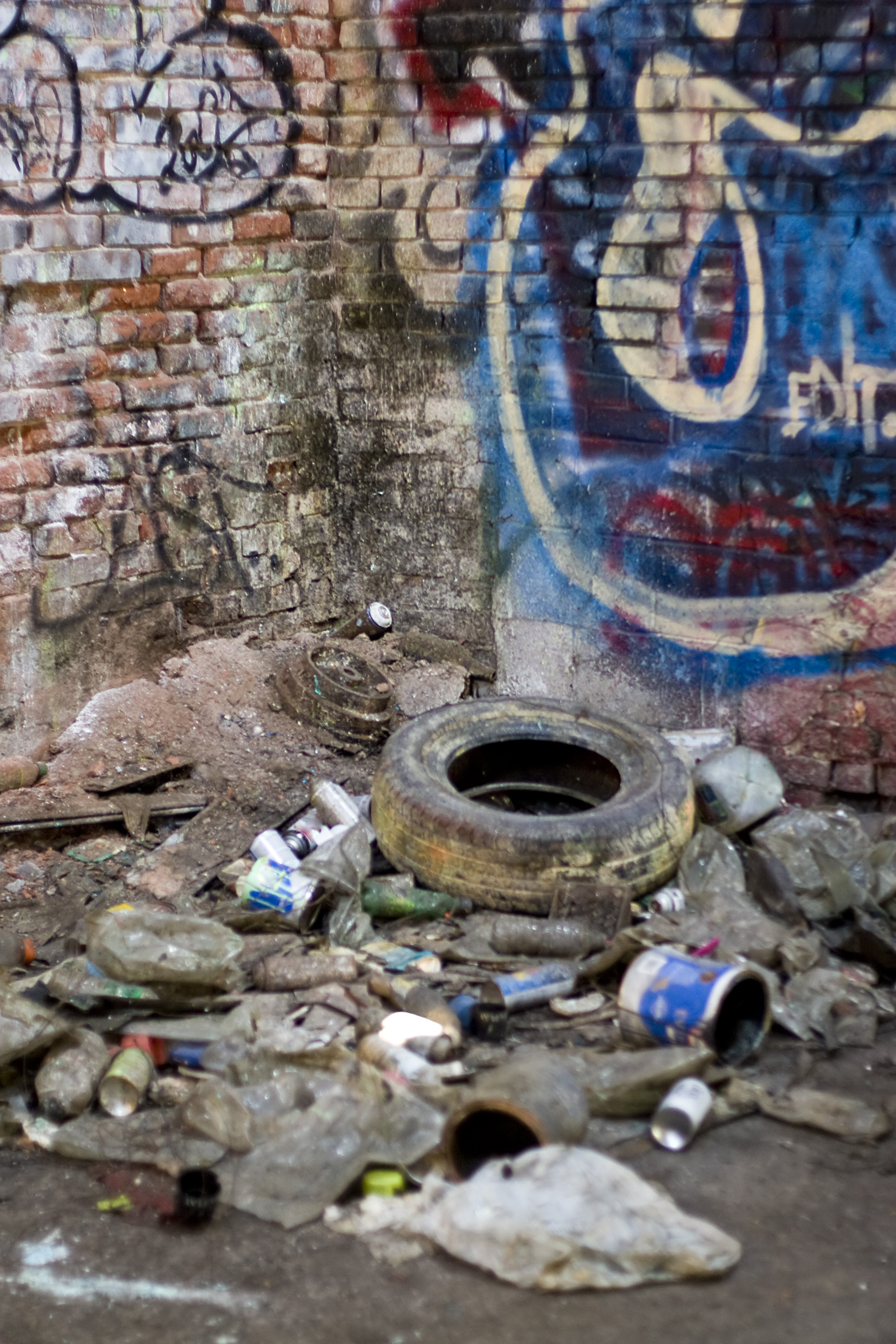 An abandoned area that is covered with trash and street graffiti. This makes an excellent background or backdrop. Shallow depth of field.